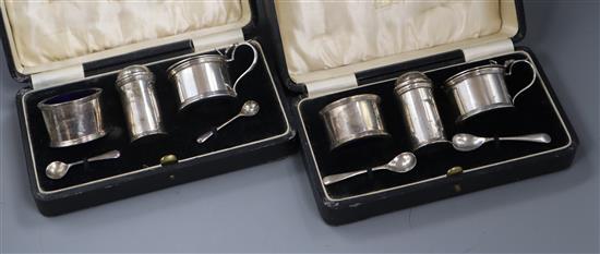 A pair of cased 1930s three piece silver condiment sets by Harrods Ltd.